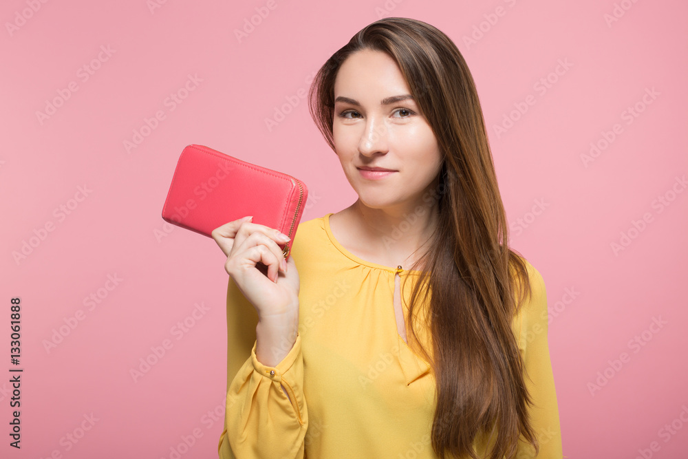 girl holding wallet next to her face over pink background isolated girl holding wallet next to her face over pink background isolated