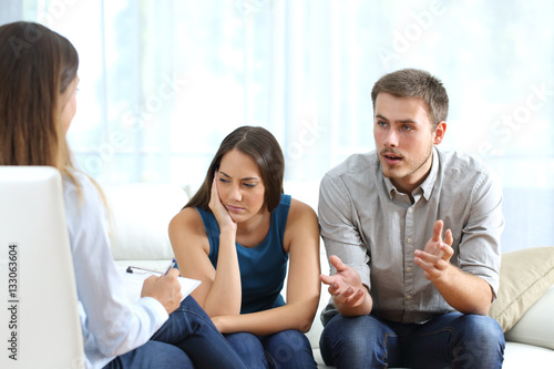Angry and sad couple talking with a marriage counselor