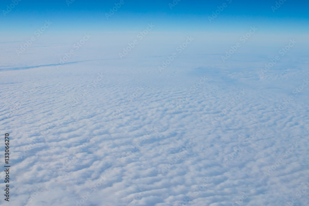 Cloudscape. Blue sky and white clouds. Sunny day. Cumulus cloud. View from the airplane