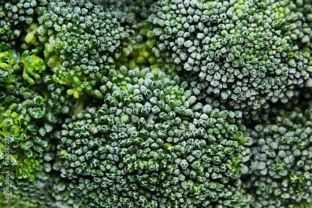 Fresh frozen green broccoli with hoarfrost closeup as background. Healthy vitamin food.