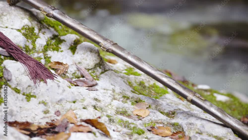 Traditional martial arts sword lying on stone rock with river in background 4K
Traditional martial arts sword lying on stone rock with river in background 4K