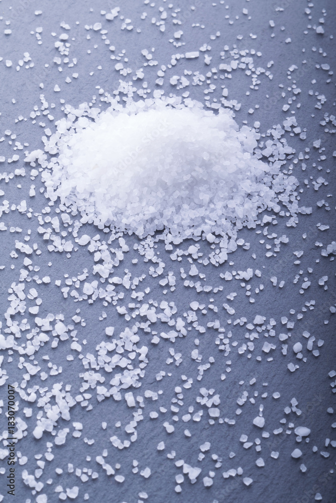 sprinkled of white salt on the stone black background sprinkled of white salt on the stone black background