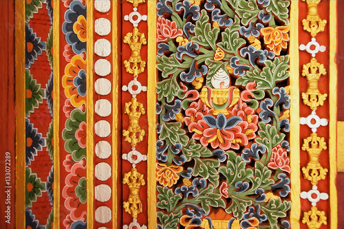 Colorful painting and carving wood work at the Dzong monastery, with buddhist symbols of tibetan stile, Bhutan
