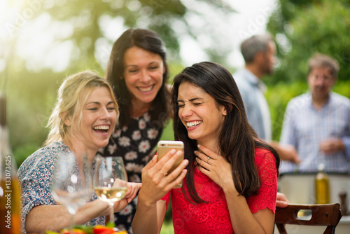 Group of female friends having fun while they watch photos