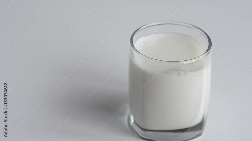 Milk poured into a glass from bottle Milk poured into a glass from bottle
