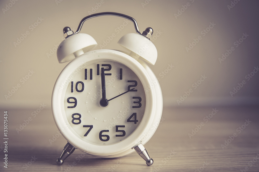 Retro alarm clock on a table. Photo in retro color image style Retro alarm clock on a table. Photo in retro color image style