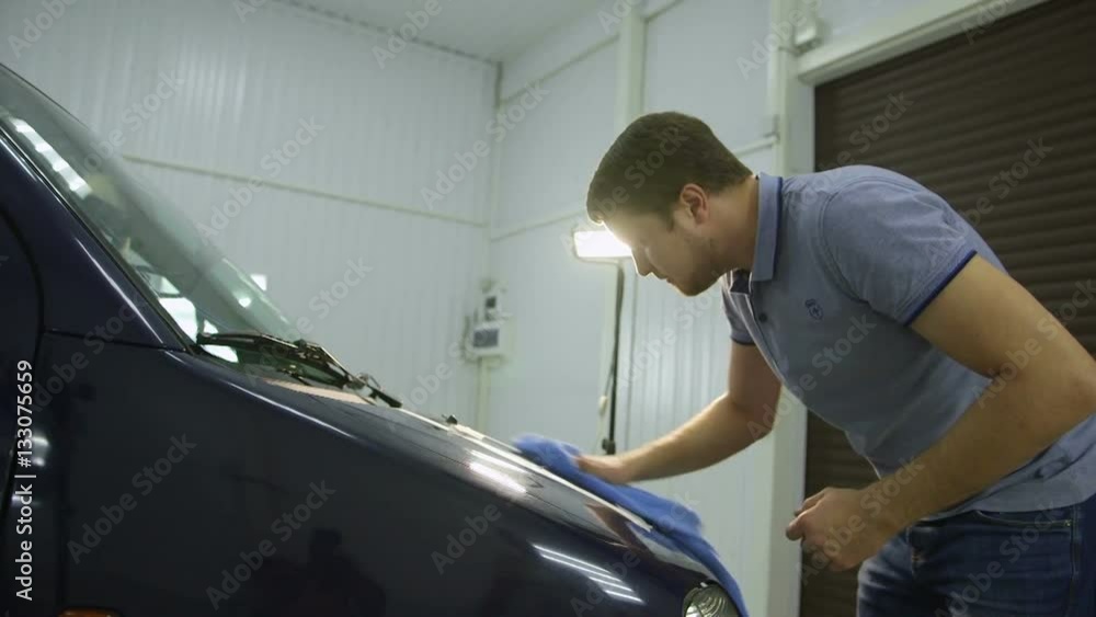 Master rubs car before polishing, the preparatory process Master rubs car before polishing, the preparatory process