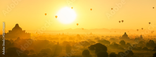 Hot air balloon over plain and pagoda of Bagan in misty morning
