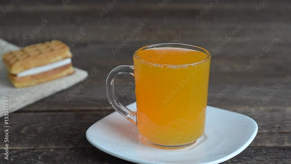 Orange juice was poured from bottle into a mug, cookies on a dark background. Artificial lighting and selective focus. Orange juice was poured from bottle into a mug, cookies on a dark background. Artificial lighting and selective focus.