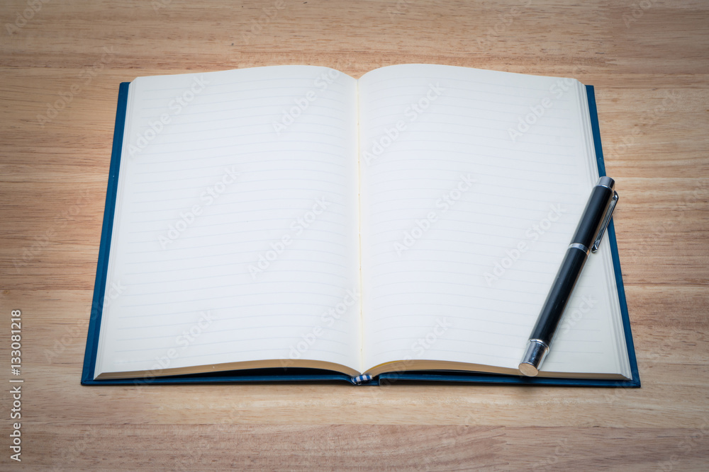 Open blank paper leather notebook with pen on wooden table. Open blank paper leather notebook with pen on wooden table.