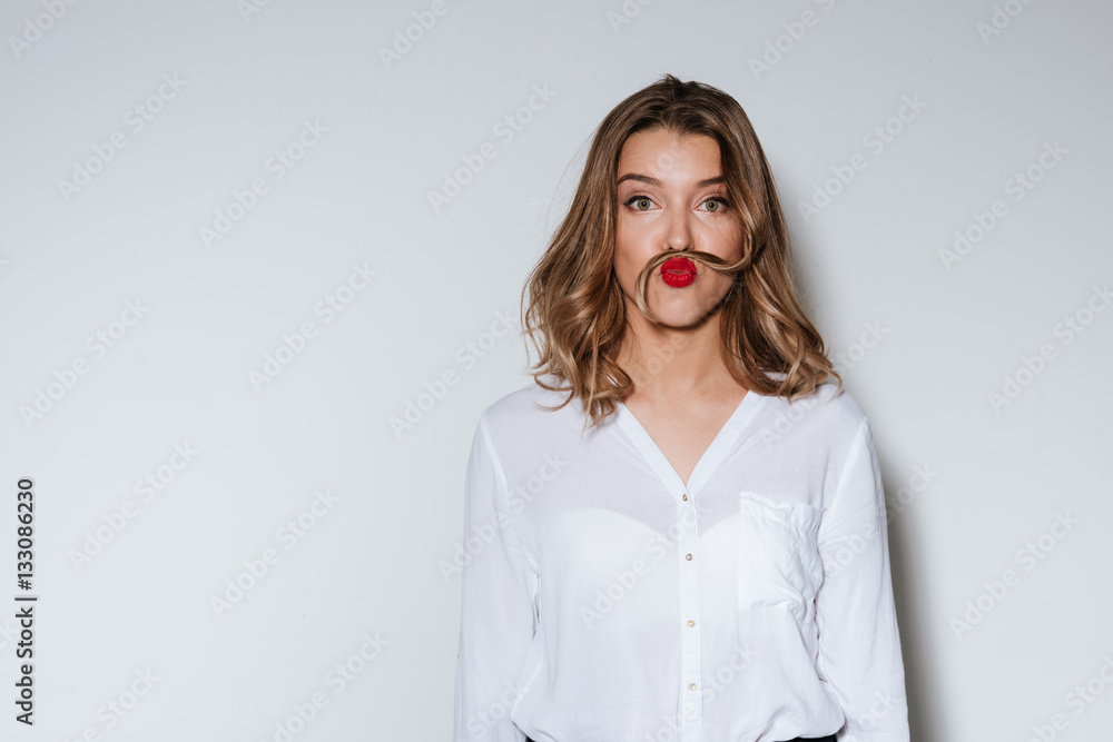 Woman making mustache with a long strand of her hair - obrazy, fototapety, plakaty 
