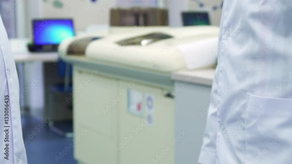 Man in white coat stretching his hands after handshaking. Close up of male hands massaging each other against background of laboratory equipment. Young scientist preparing for work at the lab Man in white coat stretching his hands after handshaking. Close up of male hands massaging each other against background of laboratory equipment. Young scientist preparing for work at the lab