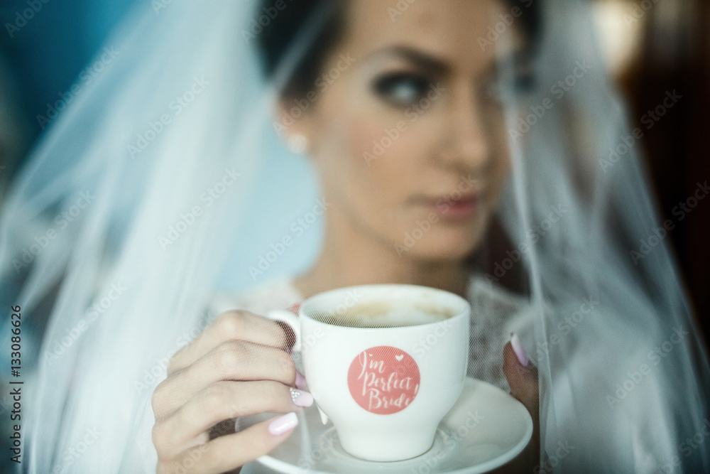 Cup of coffee with lettering 'I'm perfect bride' held by young w