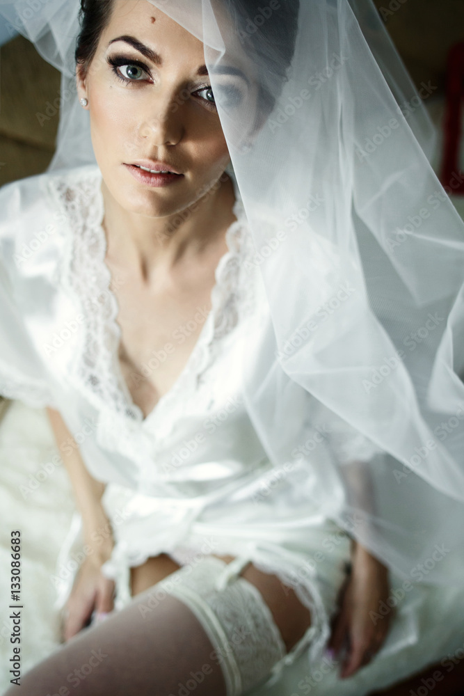 Seductive bride in silk robe and white stockings on her legs Seductive bride in silk robe and white stockings on her legs