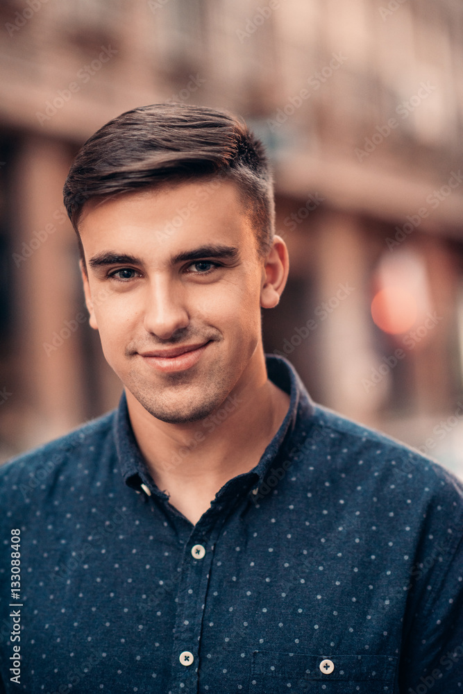 Young man smiling on a city street Young man smiling on a city street