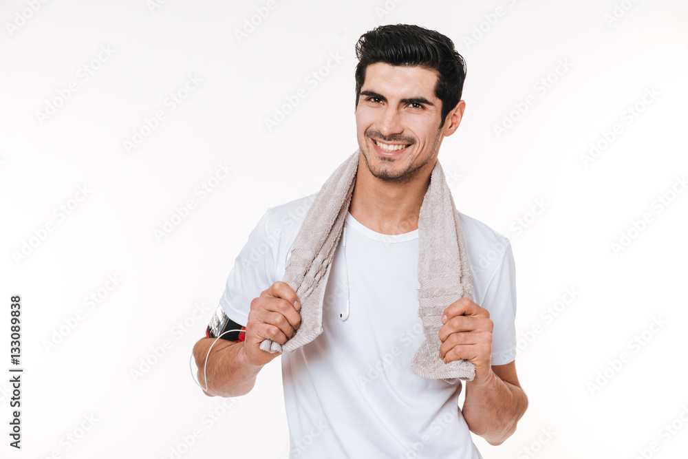 Smiling fitness man with towel on shoulders looking away Smiling fitness man with towel on shoulders looking away