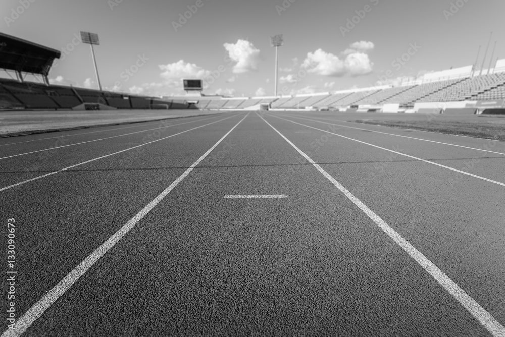 Red running track in stadium , black and white