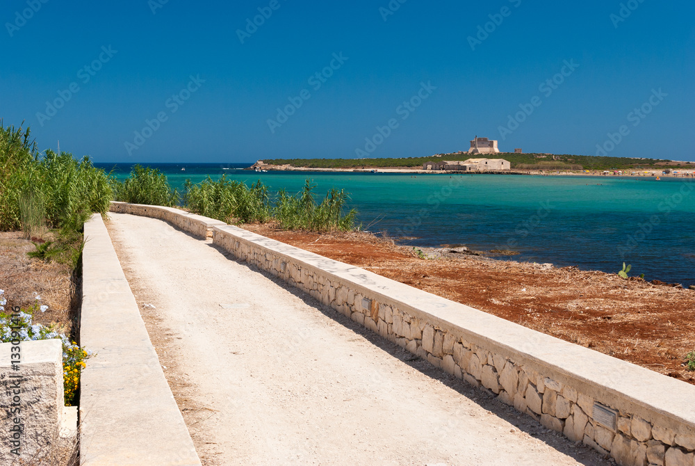 Road along the coastline in Portopalo (southern Sicily); the island of 