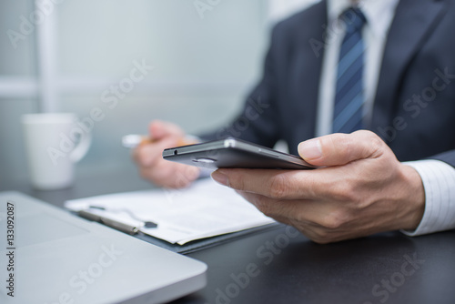 Businessman hand using mobile phone