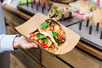 Street vendor hands making taco outdoors