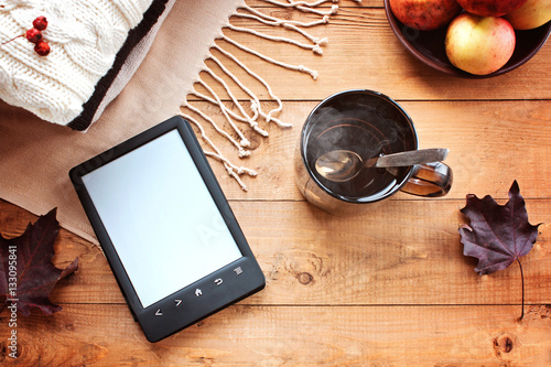 Cup of tea, the e-book, autumn maple leaves on a wooden backgrou