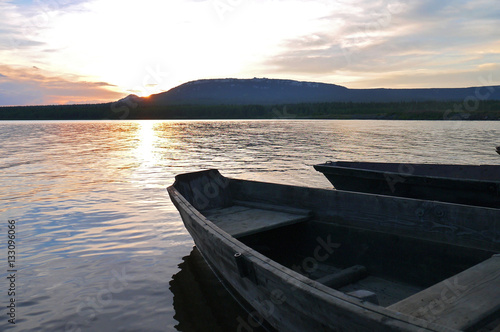 Fototapeta Naklejka Na Ścianę i Meble -  Boats on a background of mountains and a golden sunset. Lake Zyuratkul, the Zyuratkul national Park, Chelyabinsk oblast, Russia.