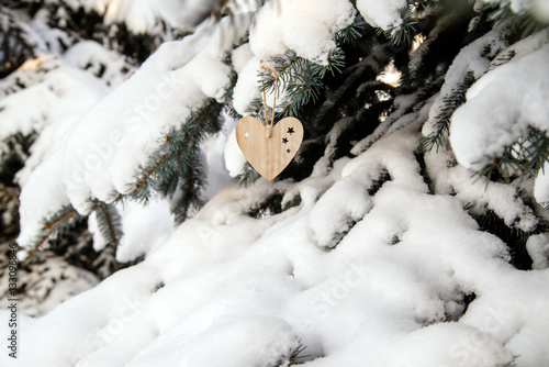 of wood toys in the form of heart hanging in the branches of trees  © licvin