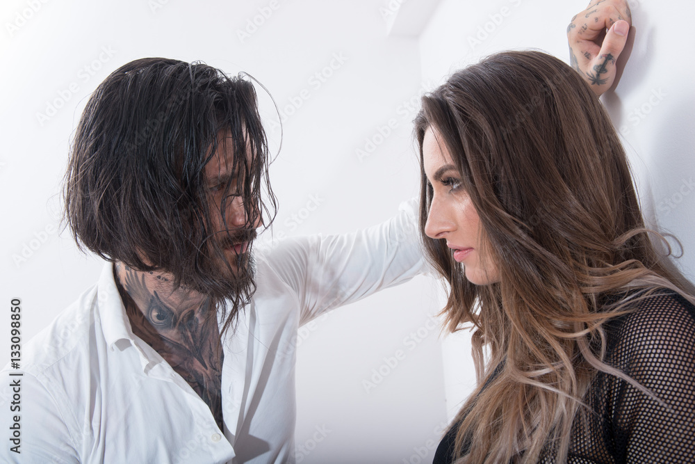 Sexy tattooed man approaching a young woman Sexy tattooed man approaching a young woman