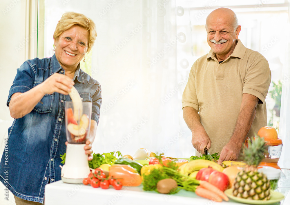 Senior couple preparing vegetarian breakfast with bio organic fruits Senior couple preparing vegetarian breakfast with bio organic fruits