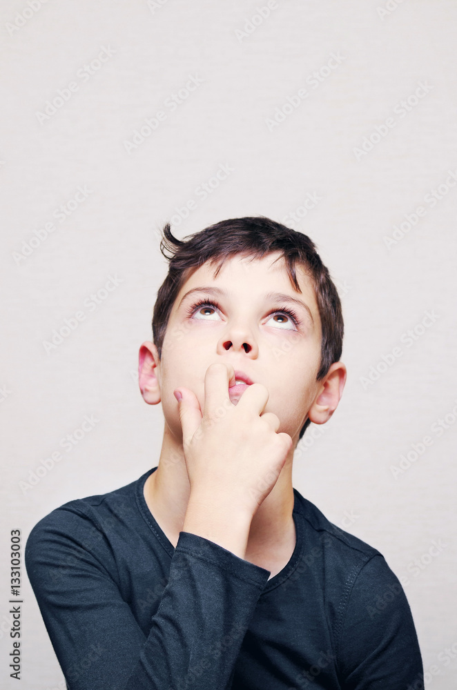 Portrait of the thought boy of the European appearance on a light background Portrait of the thought boy of the European appearance on a light background
