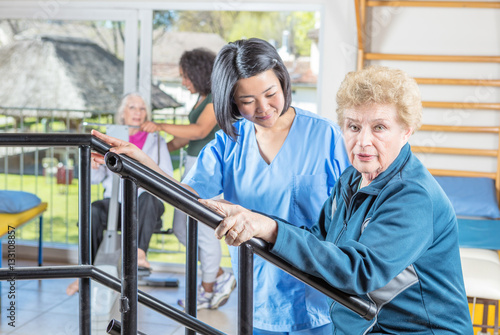 Rehab clinic gym. Multi racial nurses helping elder patients © jovannig