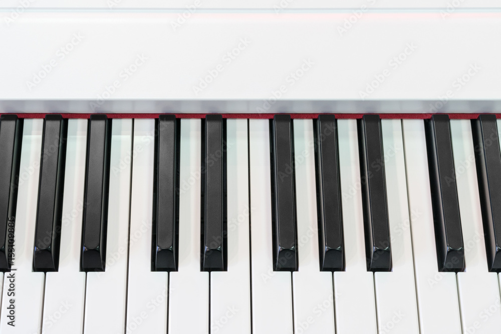 Classical piano with red decorative strip at the base of keys, close-up Classical piano with red decorative strip at the base of keys, close-up