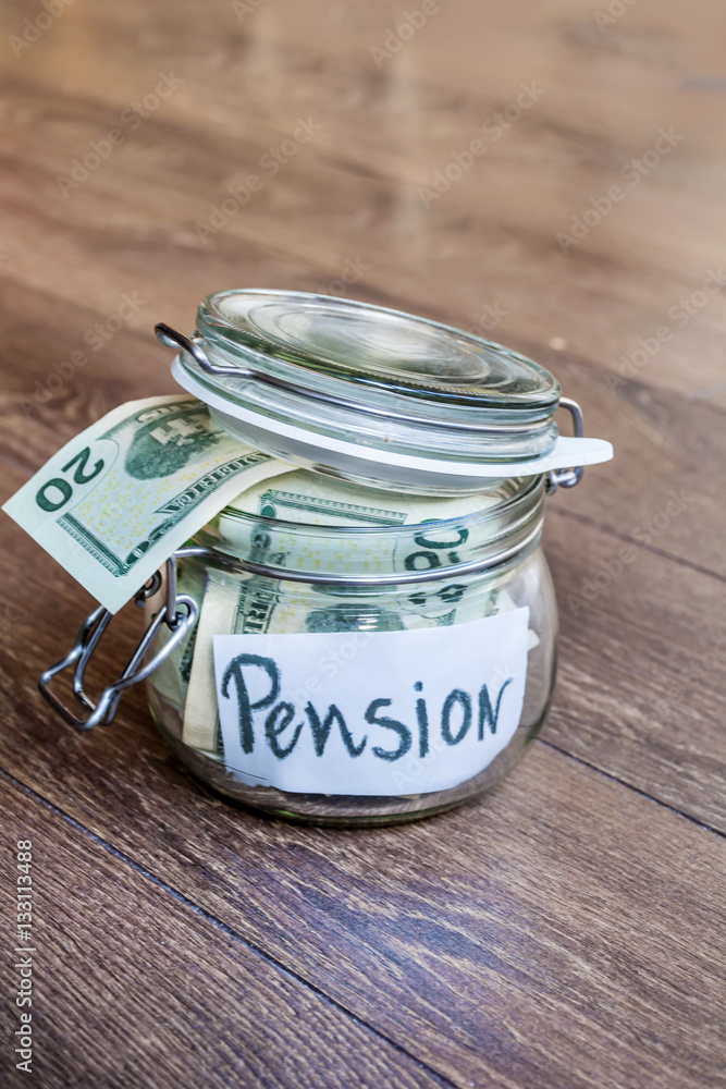 Saving money into glass jar for pension.Retirement savings Saving money into glass jar for pension.Retirement savings