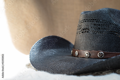 Bild auf Leinwand detail of black cowboy hat with beige background