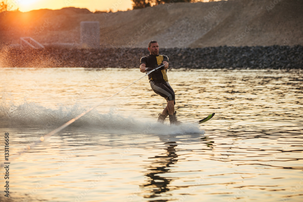 Man wakeboarding on lake at sunset Stock Photo Adobe Stock