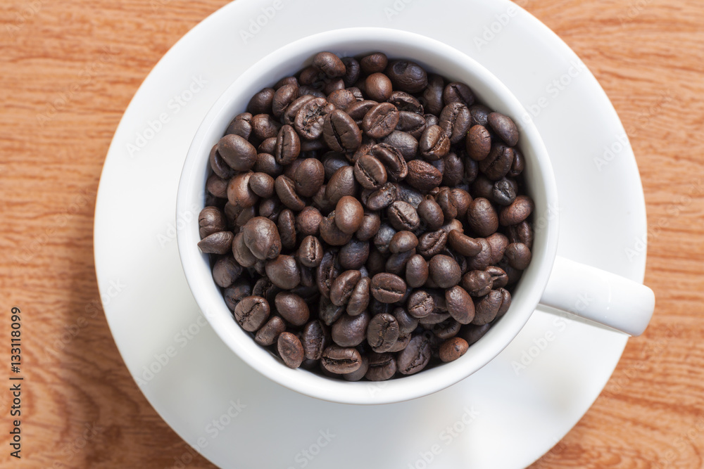 Coffee cup and coffee beans on wooden background. Top view. Coffee cup and coffee beans on wooden background. Top view.