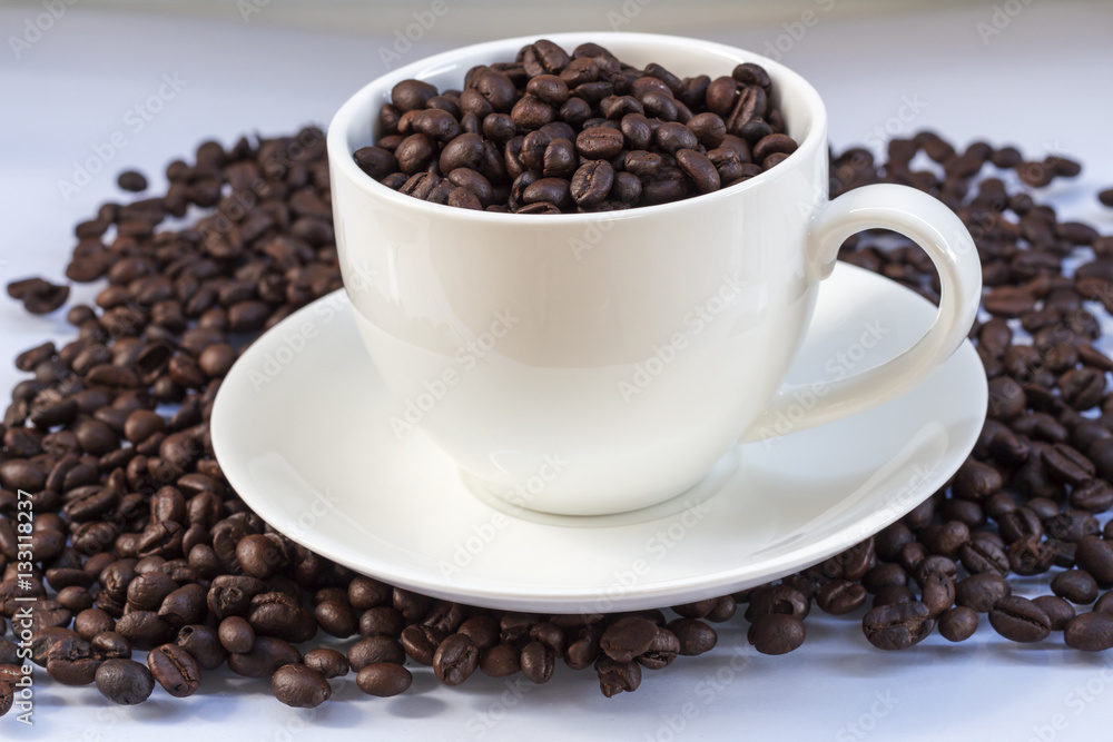 Coffee beans in coffee cup isolated on white Coffee beans in coffee cup isolated on white