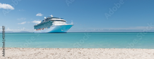 Summer vacation concept: Cruise ship in Caribbean Sea close to tropical beach.