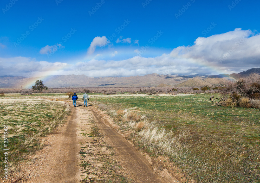 men walking under rainbow