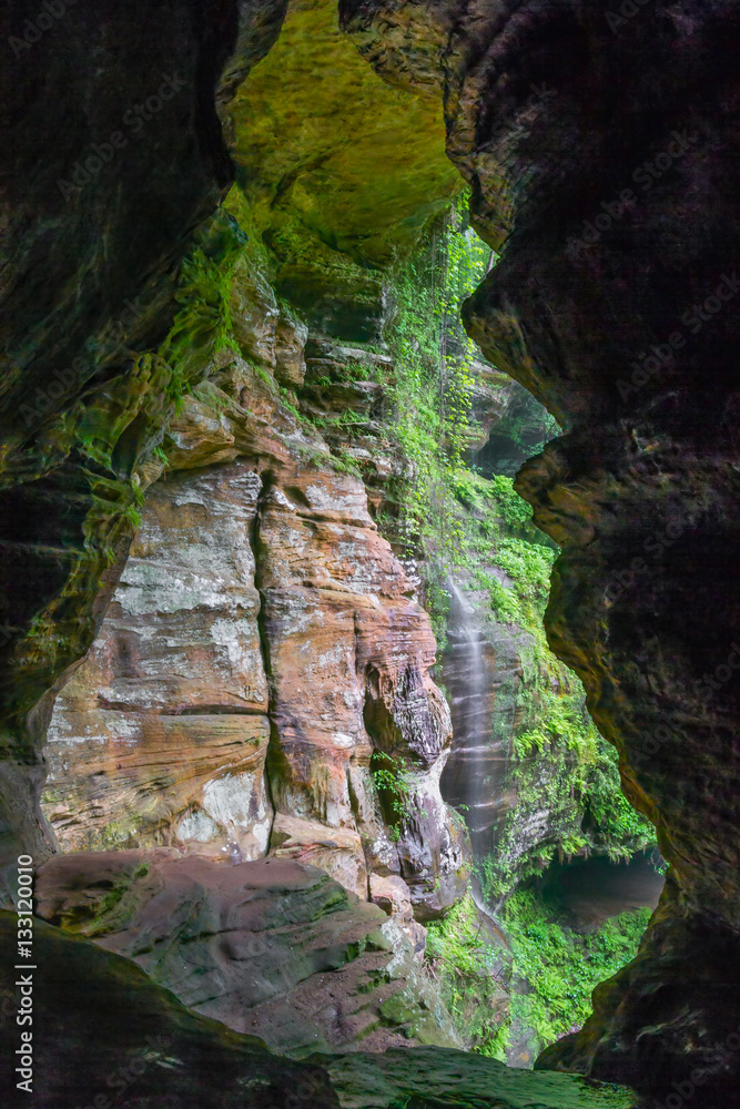 Fototapeta premium Rock House Waterfall - Waterfall on cliff side viewed from Rock House Cave in Hocking Hills State Park, Ohio