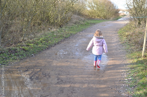 child walking through puddles 