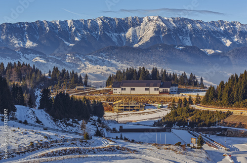 Panoramic view over the touristic ski resort Cheile Gradistei Fundata and the majestic snowy Piatra Craiului mountains range, Romania. photo