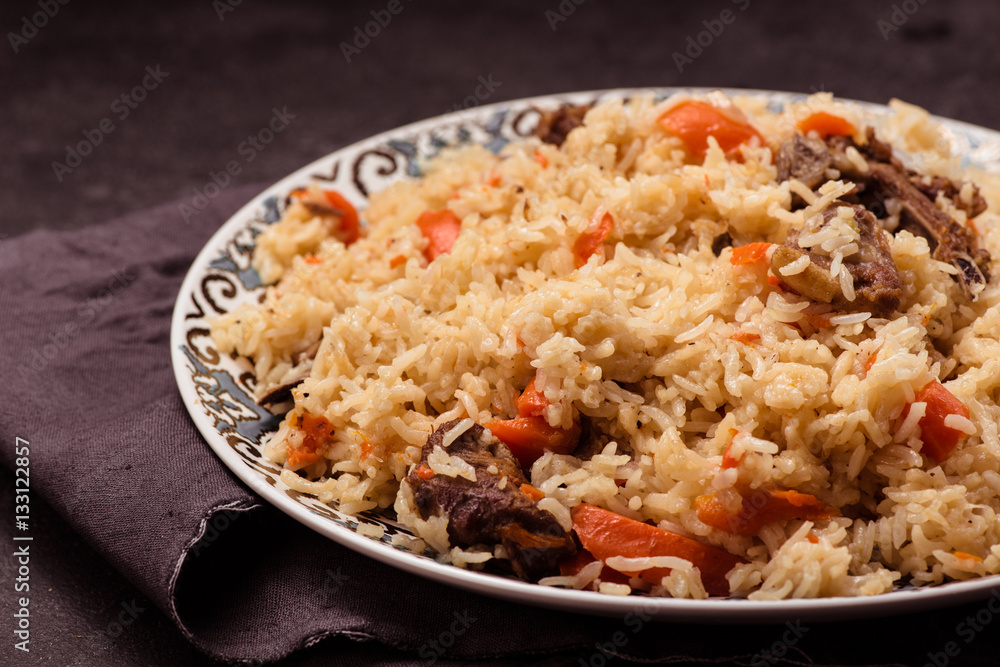 Pilaf on plate with oriental ornament. Central-Asian cuisine - Plov. Pilaf on plate with oriental ornament. Central-Asian cuisine - Plov.