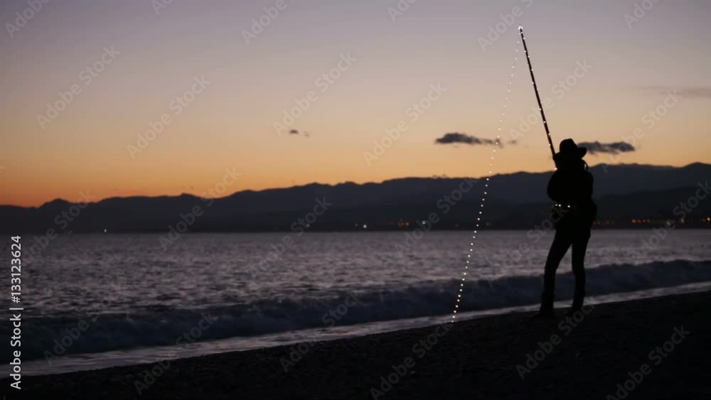 Ragazza che pesca sulla spiaggia in riva al mare dopo al tramonto Ragazza che pesca sulla spiaggia in riva al mare dopo al tramonto