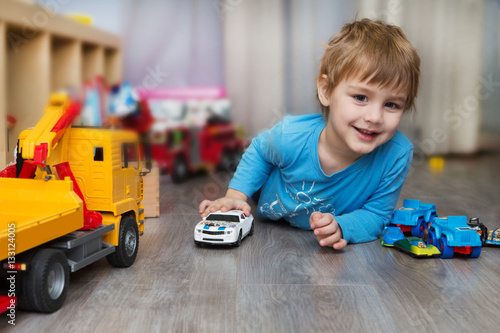 little boy plays with toy car at home
