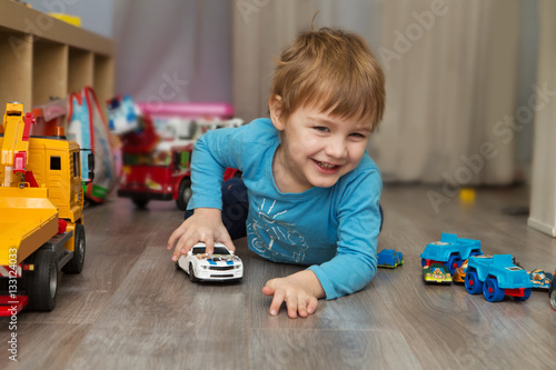 little boy plays with toy car at home