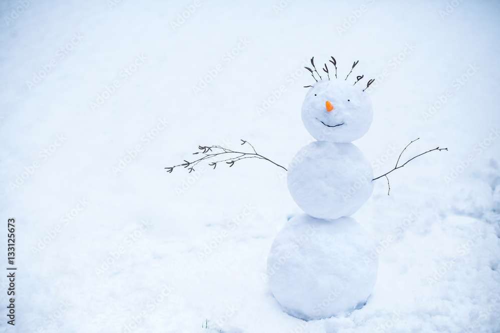 Handmade smiling snowman standing in the snow Handmade smiling snowman standing in the snow