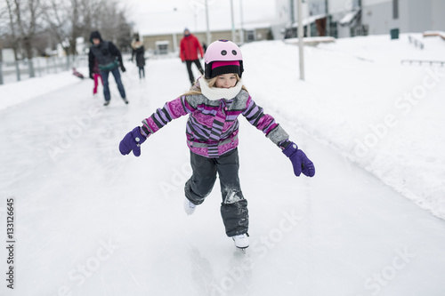 little girl enjoying ice skating in winter season