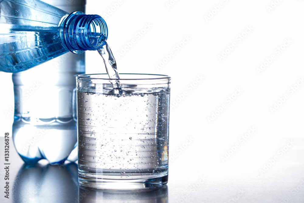 Mineralwasser aus Flasche in Glas eingeschenkt Stock Photo | Adobe Stock