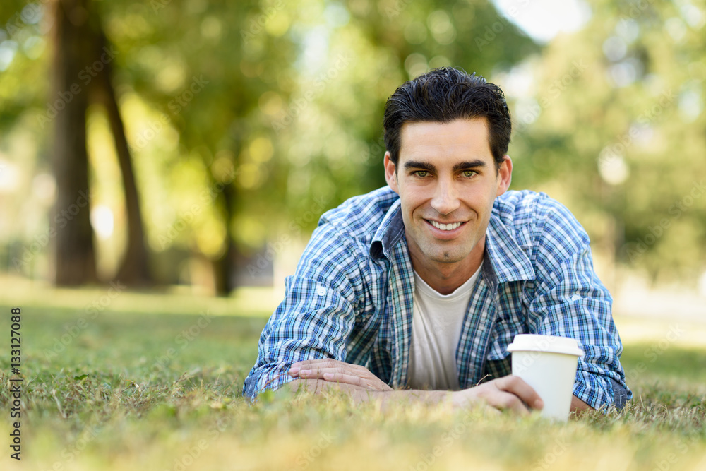 Man drinking coffee to go in an urban park Man drinking coffee to go in an urban park